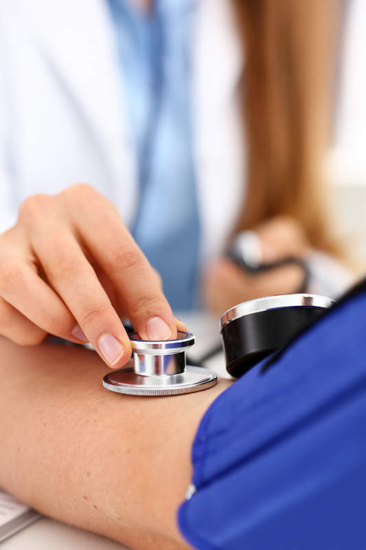 Clinica Isber - Checkup. Medico che prova la pressione ad un paziente con uno stetoscopio e lo sfigmomanometro.